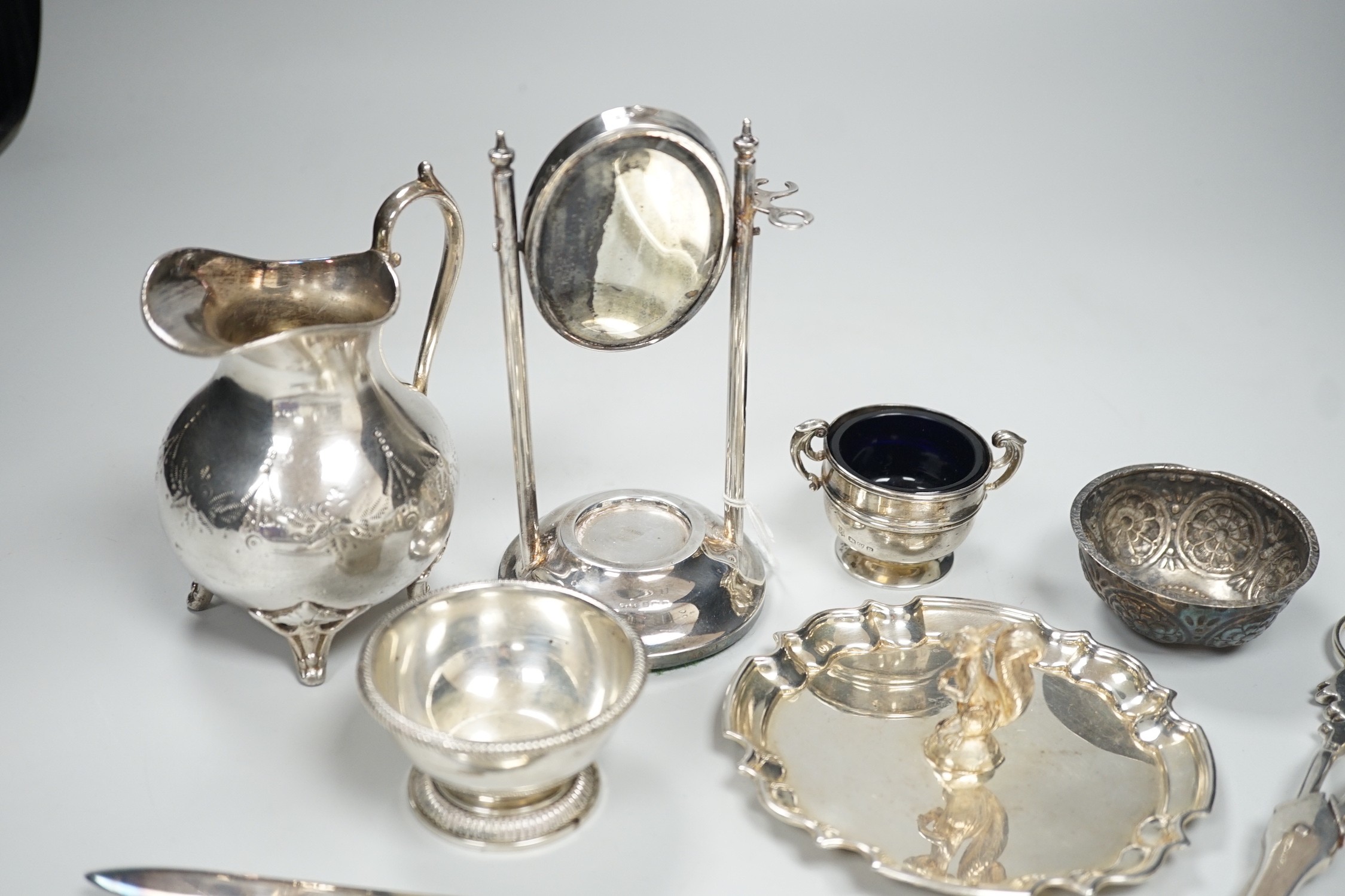 A 1920's silver mounted manicure stand with mirror and three associated implements, a small silver two handled salt, modern silver bowl, continental repousse white metal bowl, boxed modern silver letter opener and four p